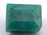 a close up of a green emerald stone on a white surface