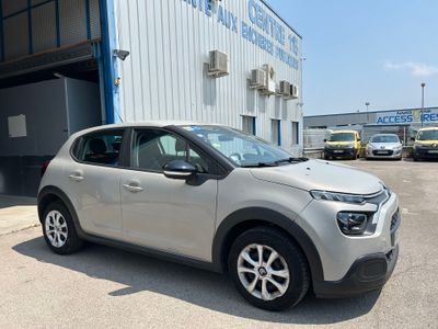 La voiture est garée devant l'immeuble, sur le parking.