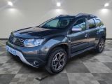 La Dacia grise est garée sur un sol à damier.