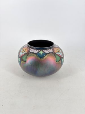 a colorful vase sitting on a table with a white background