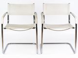 pair of chrome and leather chairs with white leather upholstered seats