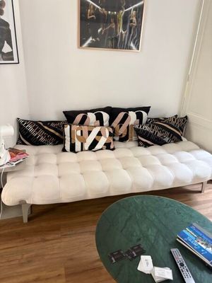 un canapé blanc avec des coussins noirs et blancs dans un salon