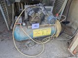 a small air compressor sitting in the corner of a building
