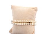 pearl bracelets on a pillow on a white background