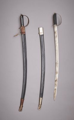 trois sabres de samouraï sont exposés sur une surface blanche