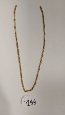 un gros plan d'un collier en or sur lequel figure un numéro