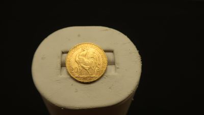 a gold coin sitting on top of a white object