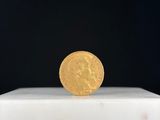 une image représentant une pièce d'or posée sur un socle blanc