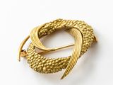 an image of a gold broochle on a white surface