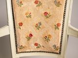an antique chair with a floral upholstered seat and back