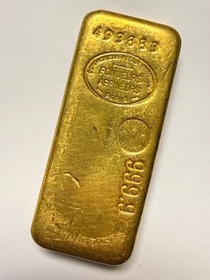 a gold bar on a white surface