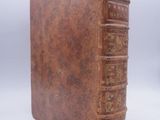 an old book sitting on top of a white table next to a white background