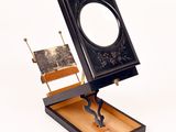 a black and white picture of a mirror and a wooden bench