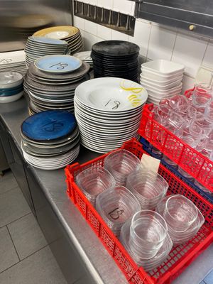 many plates and cups on the counter in the kitchen
