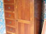 a wooden cabinet with drawers and a picture on the floor