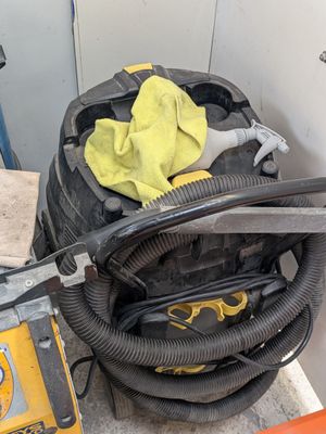 un gant jaune posé sur un aspirateur noir et jaune