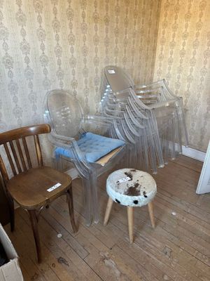 several chairs and a stool in a room with a wallpapered wall