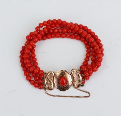 un bracelet en perles rouges avec un fermoir doré