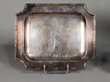 two silver trays with handles and handles on a gray surface