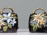 deux sacs noirs ornés de fleurs peintes, posés sur une table