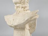 a white marble bust of a woman holding a book