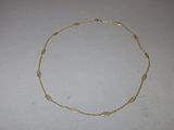 a close up of a gold necklace on a white surface