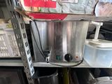 une photo d'une cafetière professionnelle posée sur une étagère
