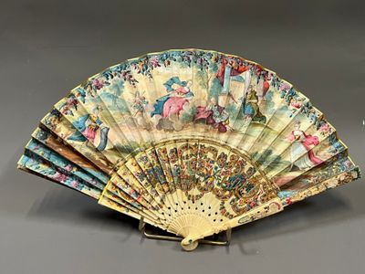 un éventail avec un tableau posé sur une table