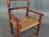 an old wooden chair with a woven seat on a gray background