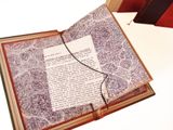 an open book with a piece of paper on top of it