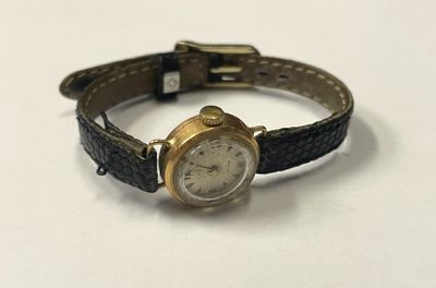 une montre posée sur une surface blanche