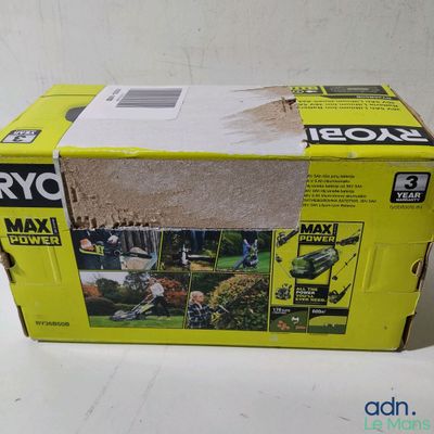une boîte posée sur une table, dans laquelle se trouve une tondeuse à gazon