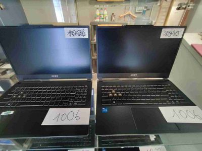 deux ordinateurs portables posés sur une table en verre, avec leurs étiquettes de prix