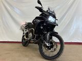a black motorcycle parked in front of a white backdrop