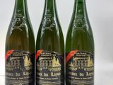 trois bouteilles de vin posées sur une table blanche
