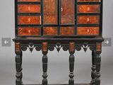 une vieille armoire en bois comportant de nombreux tiroirs, surmontée d'autres tiroirs