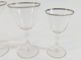 three wine glasses sitting on top of a white table next to each other
