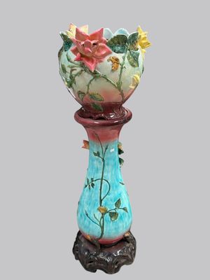 un vase surmonté d'une fleur, posé sur un socle