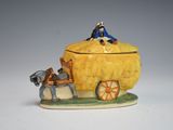 a figurine of a horse pulling a wagon with a man on it