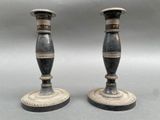 pair of antique black and gold candlesticks on a gray background