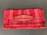 a red snake skin clutch bag with a gold clasp