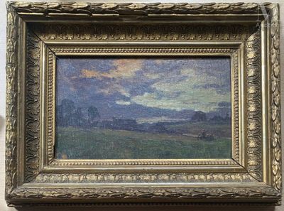 tableau représentant un paysage, encadré d'or, accroché à un mur blanc
