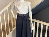 un mannequin portant une robe et un chapeau, posé sur un escalier