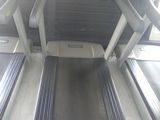 un tapis de course au milieu d'une pièce, avec un écran accroché au mur