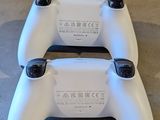 two white video game controllers sitting on the floor