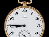 gros plan d'une montre de poche en or sur fond noir