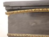 a black and gold dresser with gold trimming on it