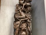 une statue représentant une femme tenant un enfant dans ses bras, posée sur une étagère en verre