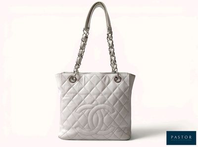 un sac Chanel blanc muni d'une poignée en chaîne argentée