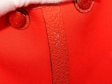 close up of a person ' s hand holding a red bag with buttons